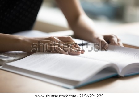 Student preparing for college test, exam, reading book, studying textbook, writing notes, making summary for class report. Learning workplace table, hands with pencil close up Сток-фото © 