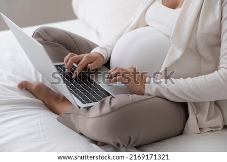 Cropped close up shot gravid woman sit on bed with laptop, future mom buy goods on-line, purchase clothes for unborn baby on internet, e-shopping, client of distance e-services for pregnant concept Imagine de stoc © 