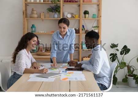 Three multi racial teammates work together on sales stats analysis, make notes take part in group meeting led buy executive manager in office. Teamwork, briefing event of diverse company staff concept 商業照片 © 