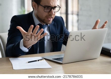 Close up annoyed unhappy businessman wearing glasses looking at laptop screen, having problem with broken or discharged device, irritated entrepreneur reading bad news in email, loss information Сток-фото © 