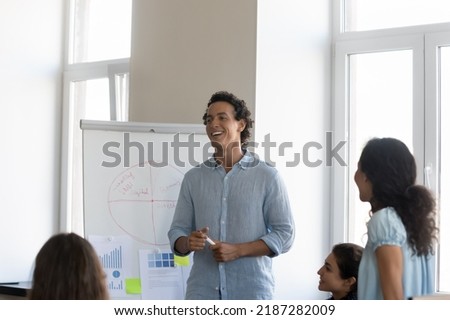 Group of young diverse staff member take part in corporate training led by Hispanic business trainer, makes presentation on flip chart. Seminar event, professional workshop activity, coaching concept 商業照片 © 