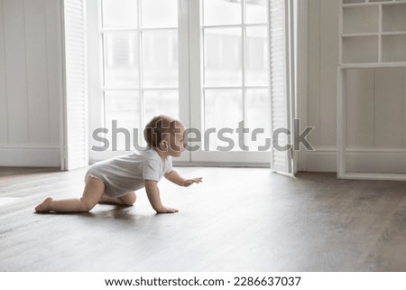 Similar – Image, Stock Photo Curious beautiful baby boy in blue body lying on playing mat, looking in the camera