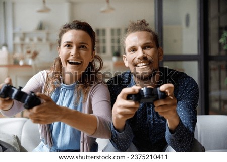 Similar – Image, Stock Photo Cheerful women playing videogame on couch