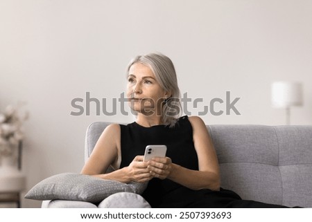 Similar – Image, Stock Photo Serious woman browsing smartphone at home