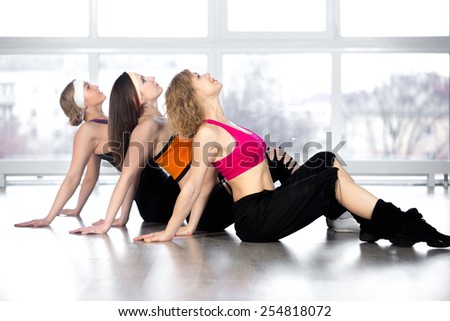 Attractive smiling young women enjoy fitness practice, dance workout in group in sport club