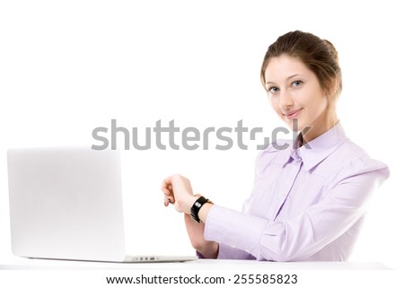 Young woman in front of laptop checking time with smile, getting on break, off work