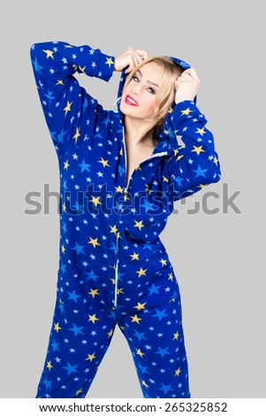 Smiling beautiful girl wearing funny blue colored pajamas with star pattern and a hood