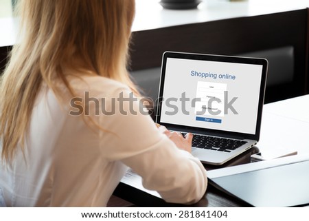 Girl shopping on-line on laptop, using online store, shopping through electronic application, signing in on website, close up, rear view