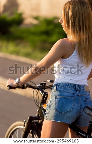 Profile of sexy sporty beautiful young woman on bike on the street on sunny summer day