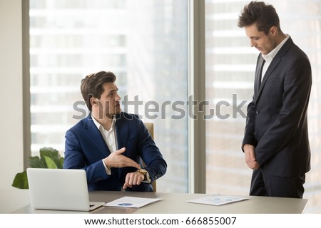Male subordinate receiving reprimand from boss for being too late at meeting, company director scolding unpunctual manager for missing deadline or not finishing work on time, pointing on wristwatch  Сток-фото © 