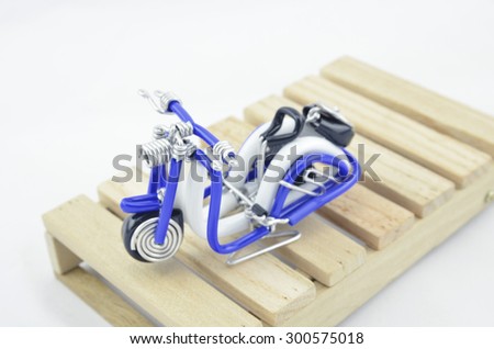 image concept wired handcraft white and blue mini scooter on wooden pallet isolated white background