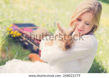 Vintage photo of teenager girl with bunny in the nature, selective focus and creative vintage editing with slightly noise