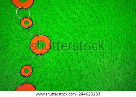 orange beads on a green knitted cloth