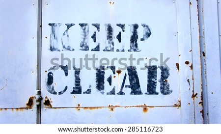 Keep Clear sigh on rusty metal door