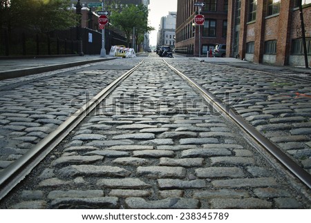 Brooklyn cobblestone street with train tracks.