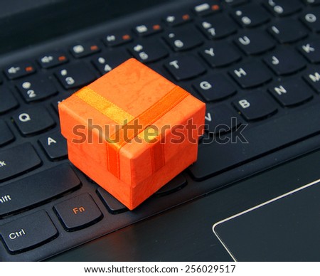 e-commerce and web shopping: orange present case on the laptop keyboard