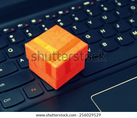 e-commerce and web shopping: orange present case on the laptop keyboard - instagram style