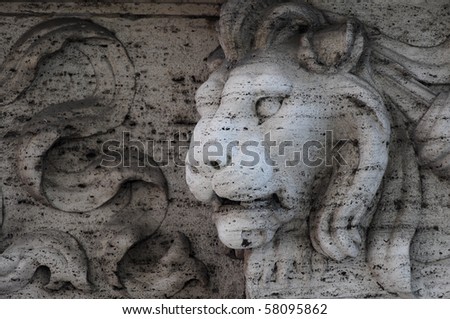 stone lion head at the base of Roman statue