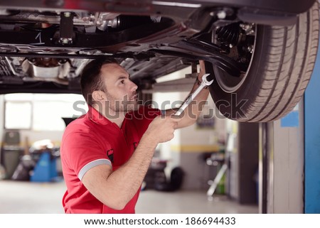 mechanic with tool checking the car