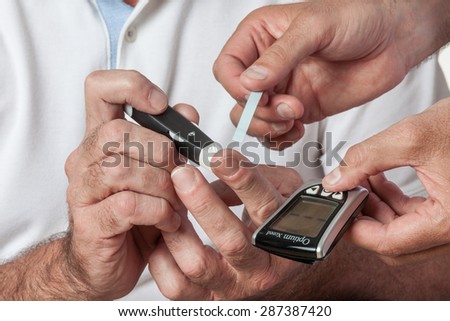 elder man using the Glucose meter
