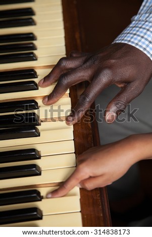 Girl learning play piano with her dad