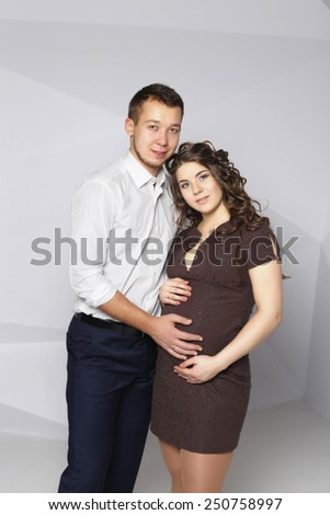 slender man standing embracing his american beautiful pregnant wife