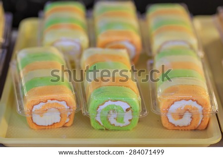 colorful yam roll on tray for sale in the cake shop