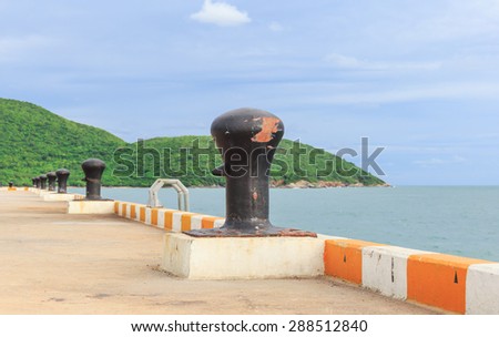 black big mooring stand in line on the port nature background