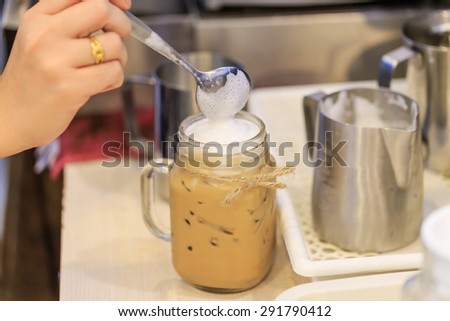 Making of ice coffee fill hot cream milk and cinnamon