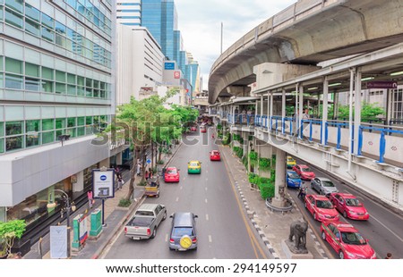 BANGKOK - JULY,7 :The Motorbikes and cars traffic move on road with pedestrian and sky-train tracks above street when holiday time of middle town. THAILAND JULY,7 2015