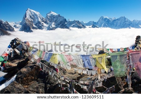 view from Gokyo Ri to Arakam Tse, Cholatse, Tabuche Peak, Thamserku and Kangtega  with prayer flags - trek to Everest base camp - Nepal