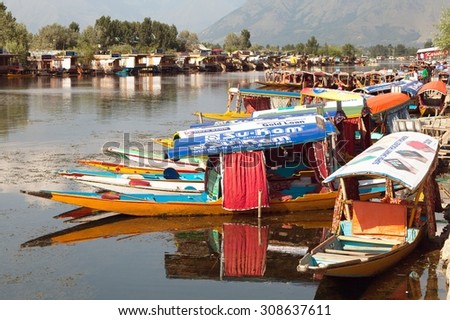 KASHMIR, INDIA - AUG 3 Shikara boats on Dal Lake with houseboats in Srinagar - Shikara is a small boat used for transportation in the Dal lake - 3rd of August 2013, Srinagar, Jammu and Kashmir, India