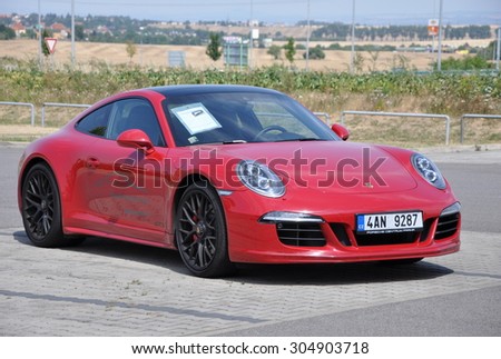 PRAGUE, THE CZECH REPUBLIC, 02.08.2015 - Luxury red Porsche 911 Carrera 4 GTS parking in front of a car store