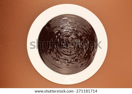 Melted semi-liquid bitter chocolate on a white plate