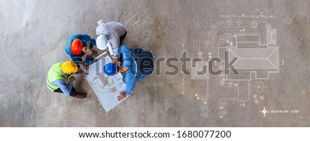 Top view of architectural engineer working on his blueprints with documents on construction site. meeting, discussing,designing, planing, roof plan