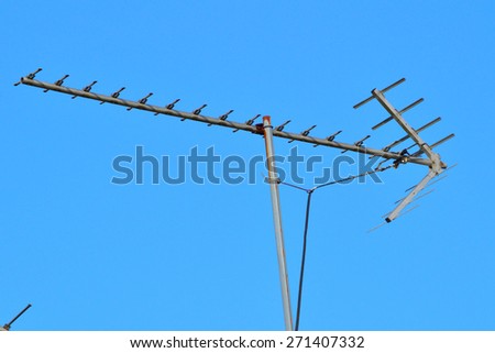 Arrow shaped antenna against a bright blue sky. Arrow pointing right.