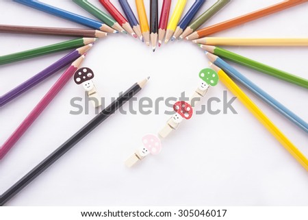 Crayon heart - Heart shape made of colored pencils and binder clip on white background