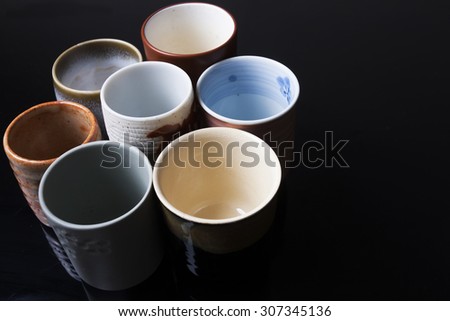 A collection of traditional Japanese cups isolated on black background