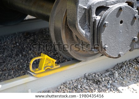 Close-up of a railway parking brake (shoe) under a train wheel. Undercarriage, passenger train, freight train. The concept of a ban on the transportation and delivery of goods by rail. Stock foto © 