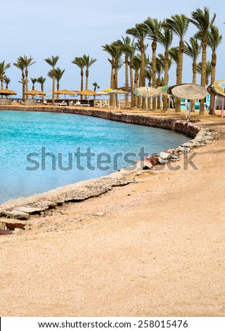 Egyptian resort with a blue lagoon and palms on the tropical beach of Red Sea.