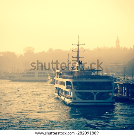 Sea voyage on Bosporus - traditions water transport of Istanbul. Silhouettes of turkish steamboat in Istanbul at sunset. Vintage passenger ship with soft light effect - travel concept in retro style.