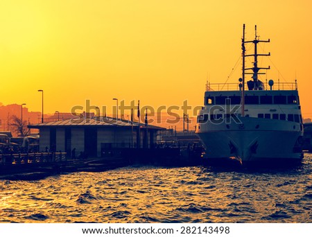 Sea voyage in Golden Horn on the ferryboat. Silhouettes of turkish steamboat,  Stambul harbor at sunset. Old passenger ship, golden sundown in Istanbul.