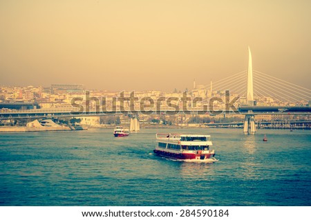 Sea voyage on the tourist motorboat, seaside view of Istanbul. Turkish steamboat in Golden Horn at sunset. Two passenger ships and New Bridge - travel in Turkey.