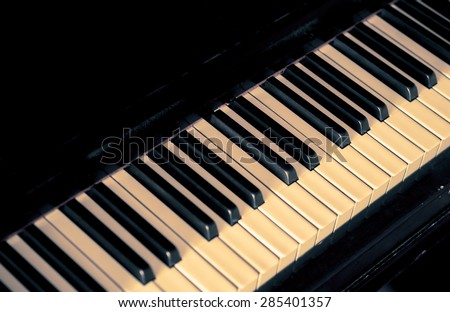 Musical background with piano keys. Music concept with old classic musical jazz instrument. Piano keys in retro style with copy-space for text on black color background.