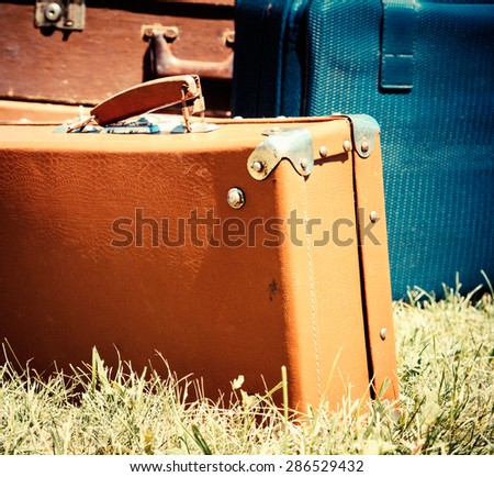Vintage travel bags and old suitcases. Old leather suitcases at outdoor, film colors toned in retro style. Vintage travel concept with baggage in a warm colors and sun light.