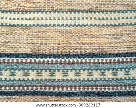 Handmade home textile - background of carpet in pastel colors. Tapestry with decorative pattern and strips. Woven ornamental rug - traditions craft and decor for ethnic stylish interior in Ukraine.