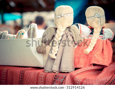 Puppets for sale on ethnic fair - rag dolls in a folk style, old slavonic tradition. Slavic girl\'s dolls on a fair, backside view.
