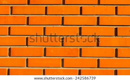 Texture, background is. Detail of a wall laid out from decorative orange brick. Modal sun, warm light.