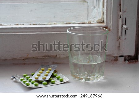 Objects. Medicine. Pills and a glass of water on an old windowsill in the hospital....