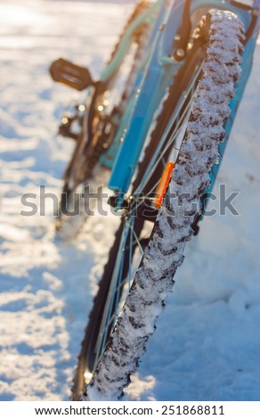 Sport. Medium shot of the rear wheel bike on snow background. Winter. Without the use of filters, enhanced contrast.
